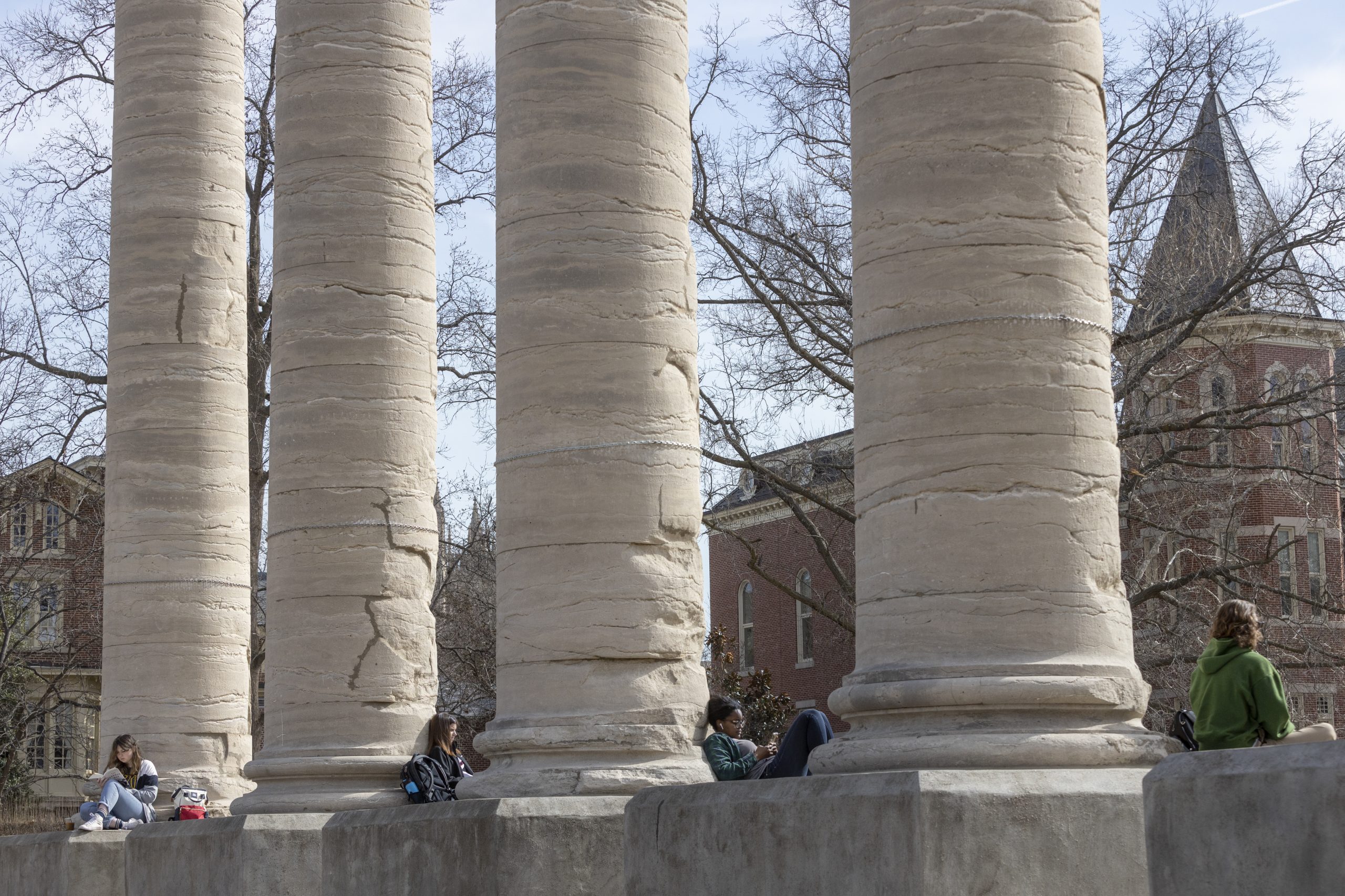 Students sit on the columns at the David R. Francis Quadrangle