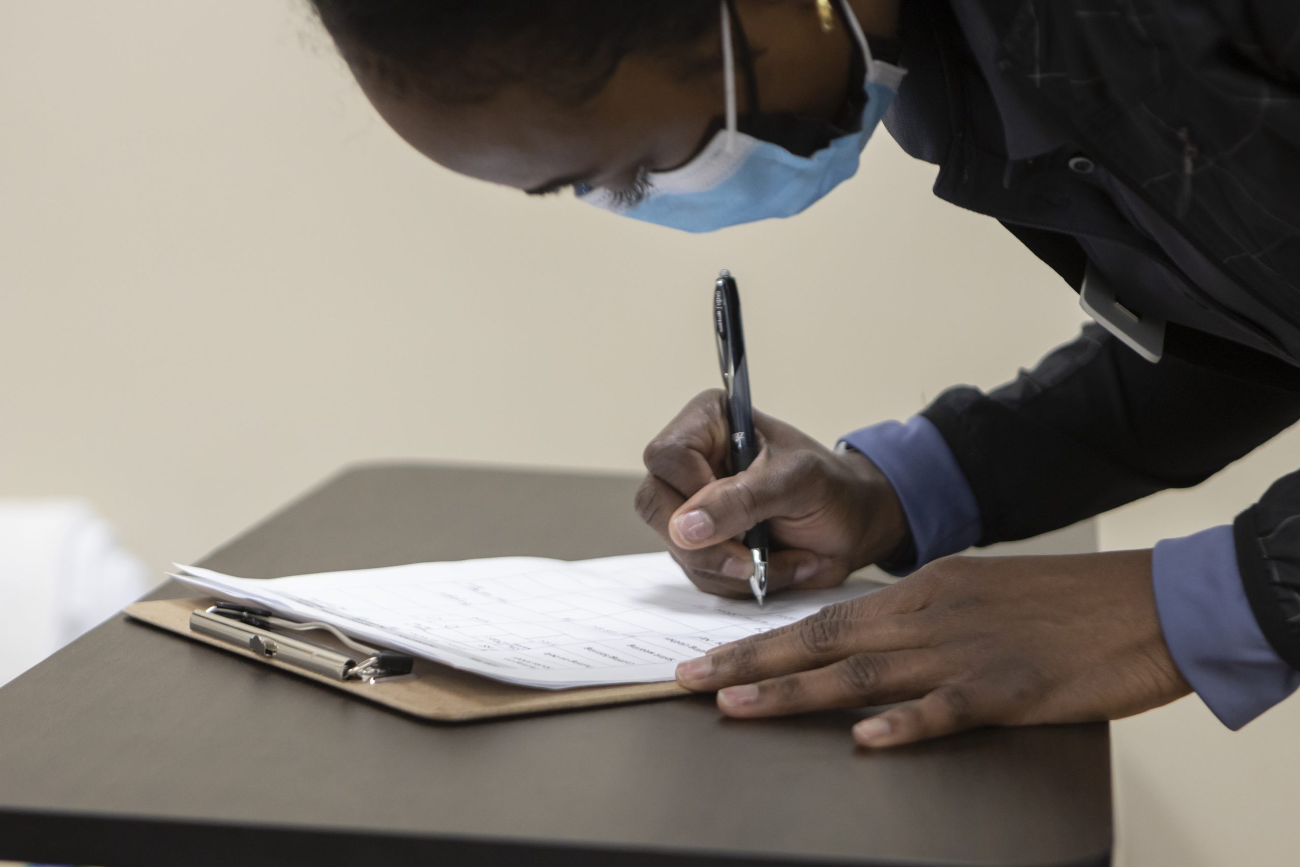 Man signs a form on a clipboard