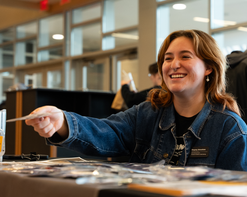 Student passing out materials at event.